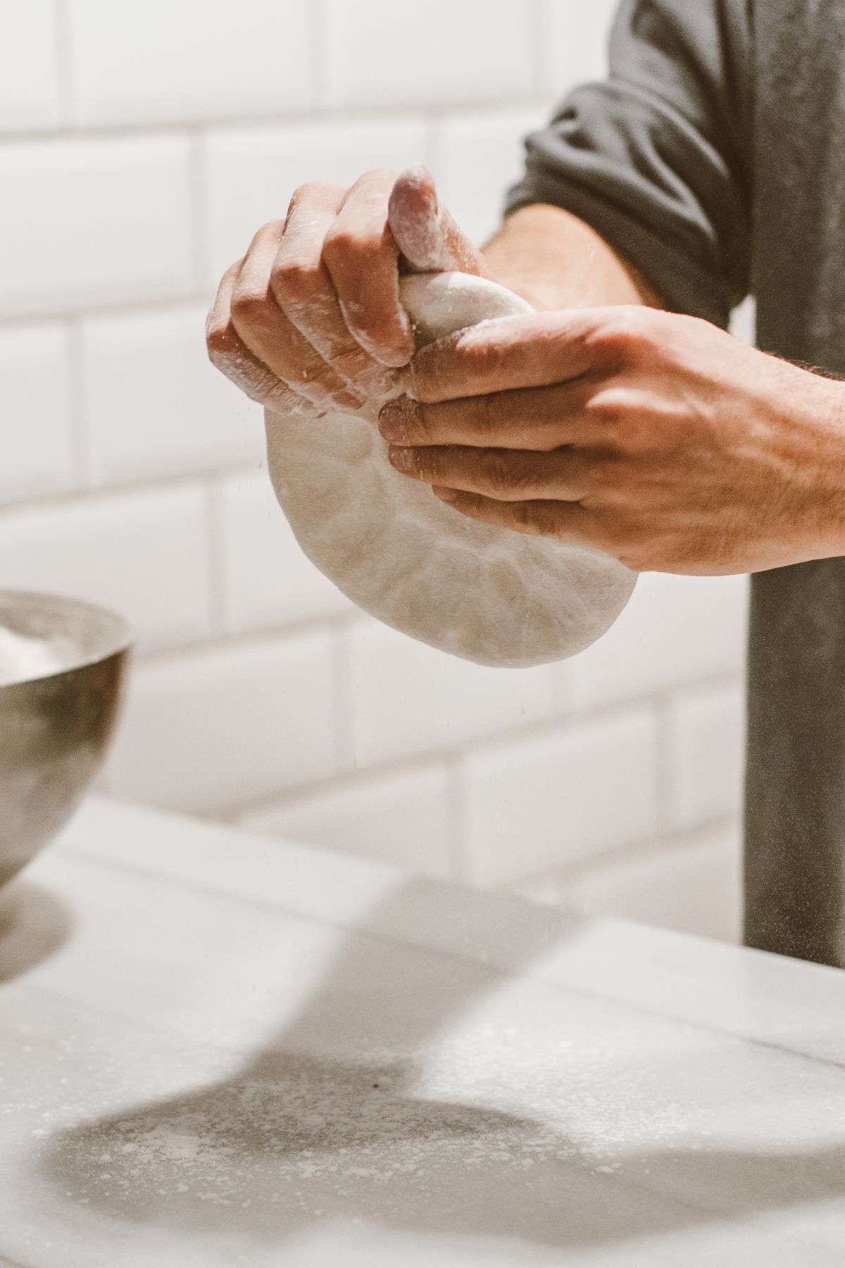 Hands stretching fresh pizza dough