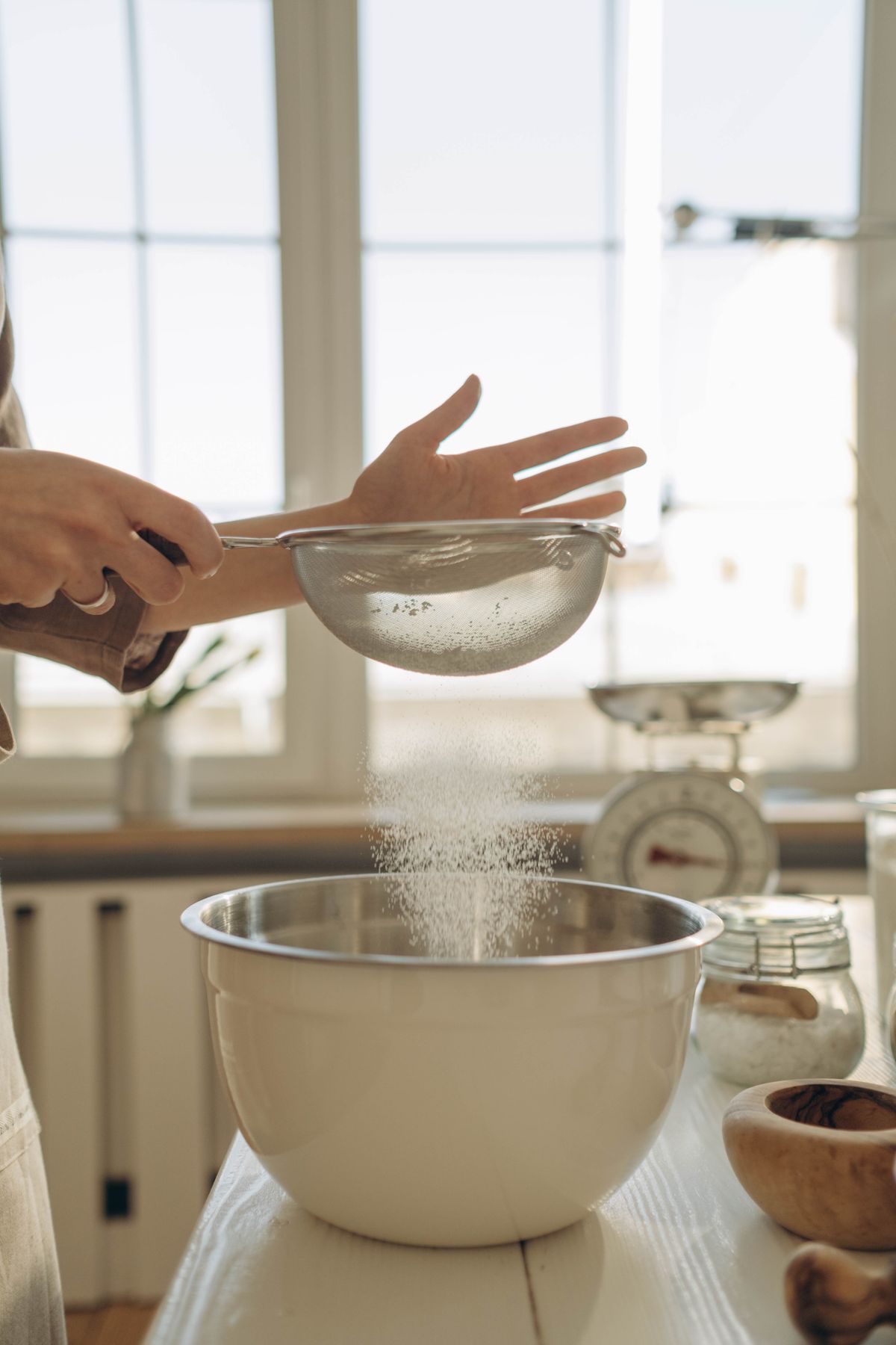 Flour being sifted into a mixing bowl
